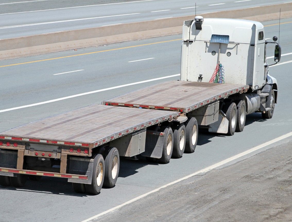 Empty flatbed semi-truck traveling on a highway