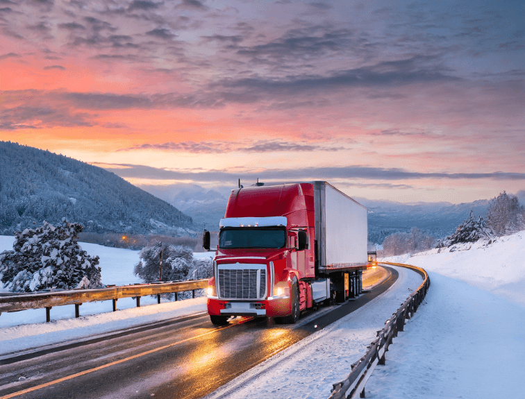 Image of red semi truck driving on highway with snowy landscape