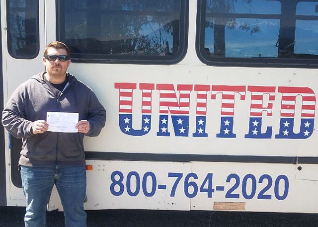 image of united grad with certificate in front of United bus
