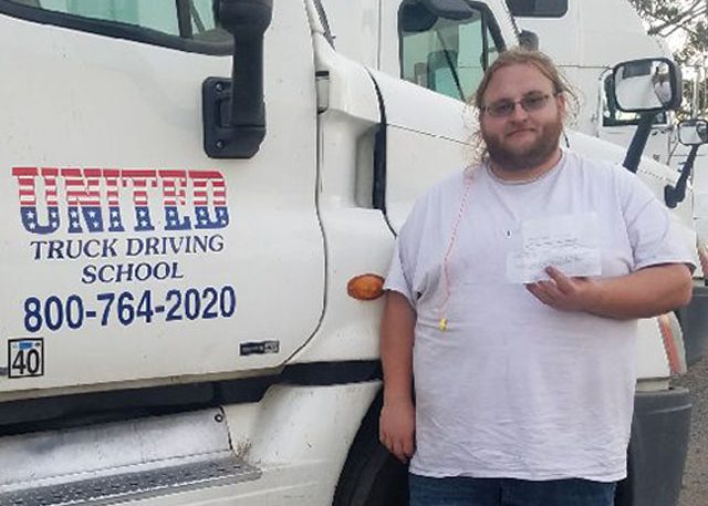 Image of Brock Adkins with certificate in front of United truck