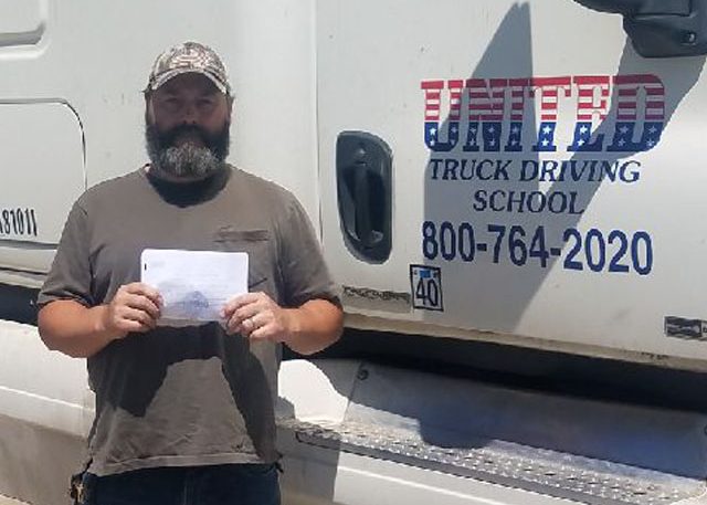 Image of Michael Lohr with certificate in front of United truck