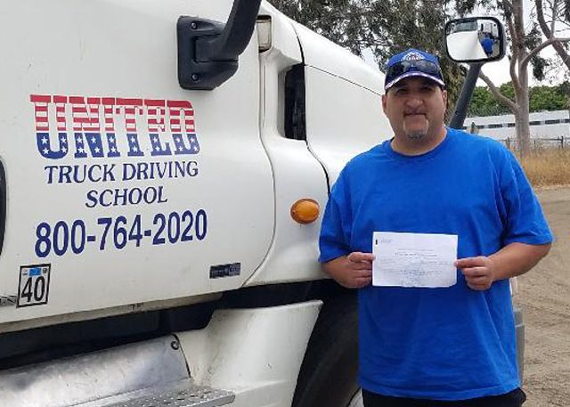 Image of Michael Soto with certificate in front of United Truck