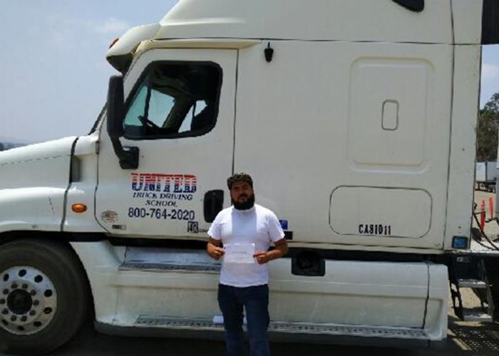 Image of Dario Lopez with certificate in front of United truck