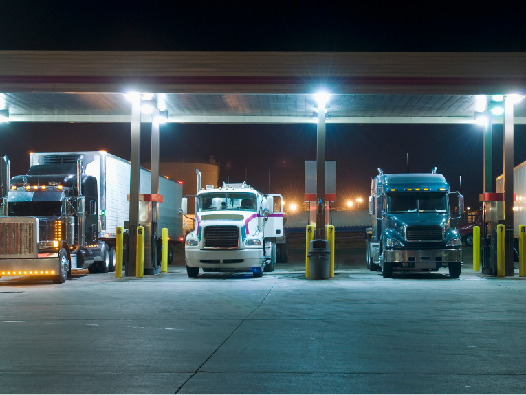 Image of three trucks at gas station
