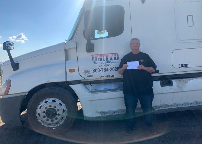 Image of John Gorman with certificate in front of United truck