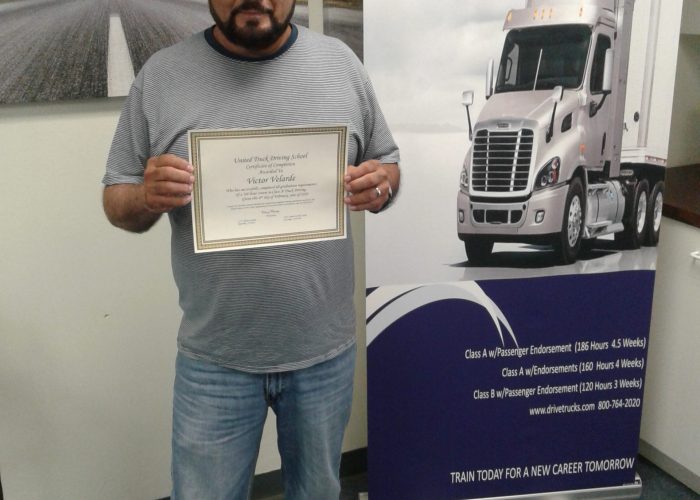 Image of Victor Velarde standing with his certificate