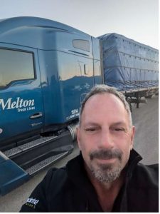 Image of Tim Sherman standing in front of a blue Melton truck