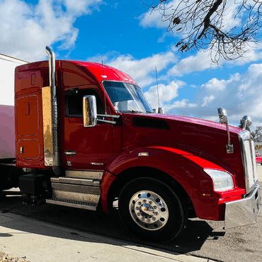 United Truck Driving School red semi truck parked. Blue sky.