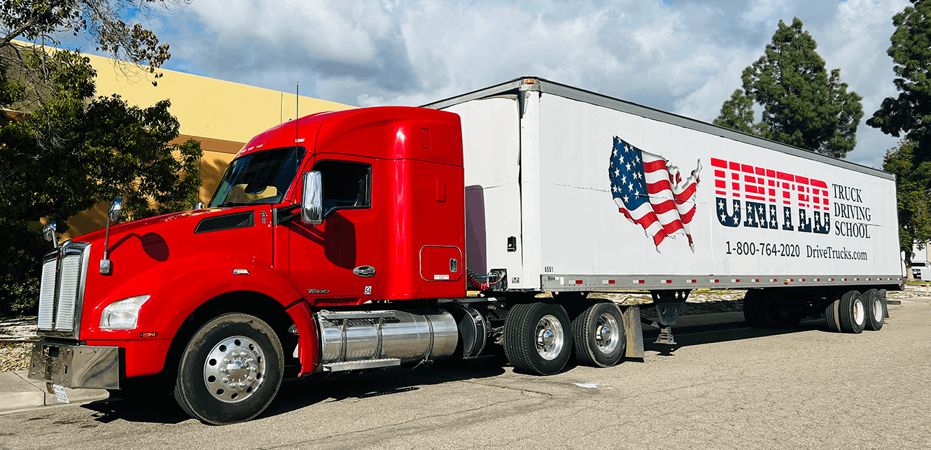United Truck Driving School red semi truck parked. Logo on side of trailer.